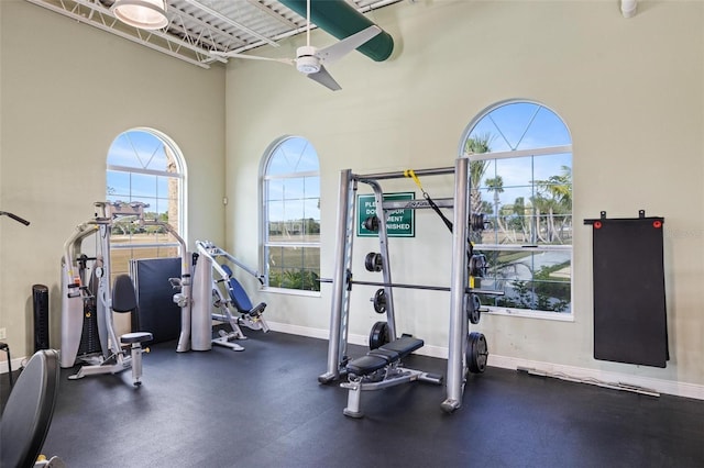 workout area featuring a towering ceiling and ceiling fan