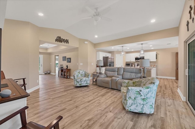 living room with light hardwood / wood-style floors, ceiling fan, and vaulted ceiling