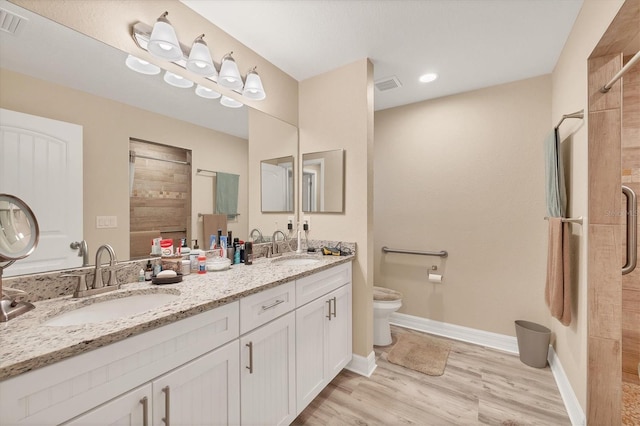 bathroom featuring hardwood / wood-style floors, vanity, toilet, and a shower