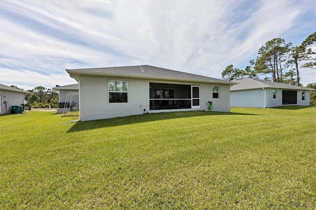 rear view of property with a lawn and a sunroom