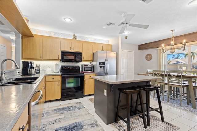 kitchen with sink, a center island, hanging light fixtures, light brown cabinetry, and black appliances