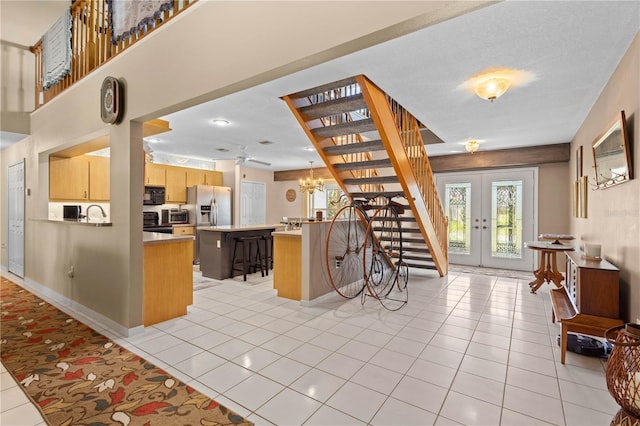 kitchen with stainless steel fridge, french doors, light brown cabinets, a center island, and a breakfast bar area