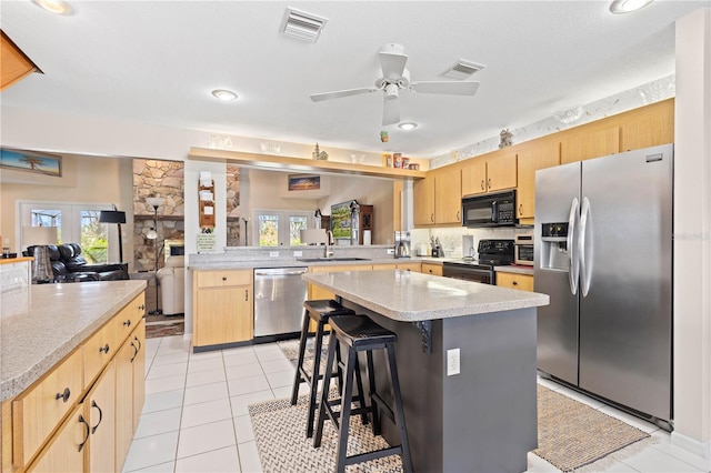 kitchen featuring black appliances, visible vents, and a center island