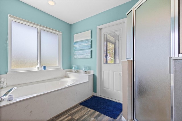 bathroom featuring wood-type flooring and shower with separate bathtub