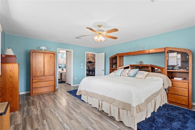 bedroom with visible vents, a spacious closet, ceiling fan, wood finished floors, and baseboards