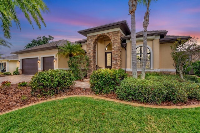 view of front of property featuring a yard and a garage