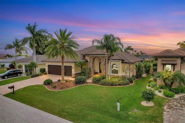 mediterranean / spanish-style house with a yard and a garage