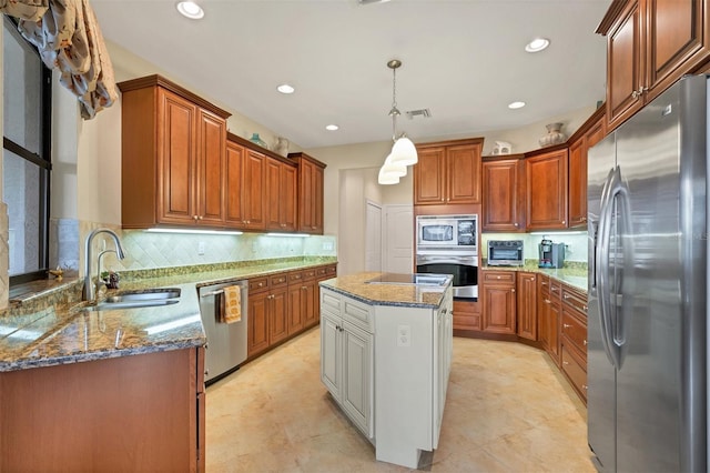 kitchen featuring pendant lighting, stone counters, sink, stainless steel appliances, and a center island