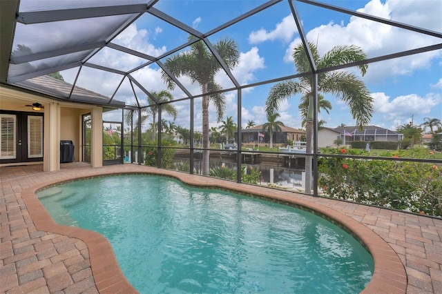 view of swimming pool with a water view, a patio, and a lanai