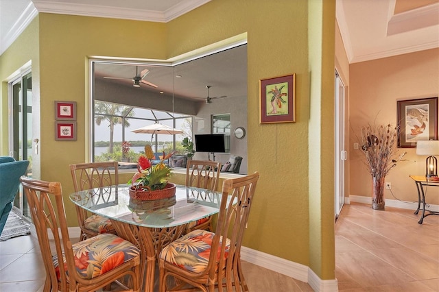 tiled dining area with ceiling fan and ornamental molding