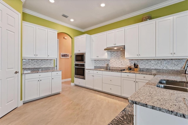 kitchen with appliances with stainless steel finishes, white cabinetry, sink, and tasteful backsplash