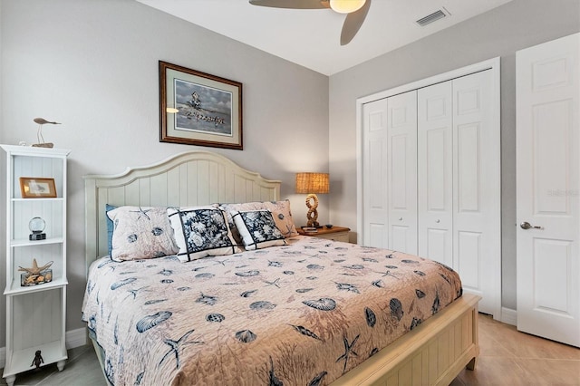 tiled bedroom featuring ceiling fan and a closet