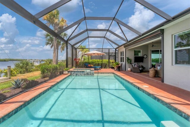 view of pool featuring an in ground hot tub, ceiling fan, glass enclosure, and a patio area