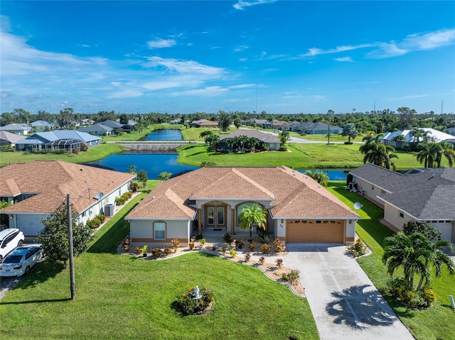 240 White Marsh Ln, Rotonda West, FL 33947 - view of front of house with a water view, a residential view, a garage, a front yard, and driveway