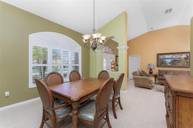 dining space with a notable chandelier, vaulted ceiling, ornate columns, and light tile patterned floors