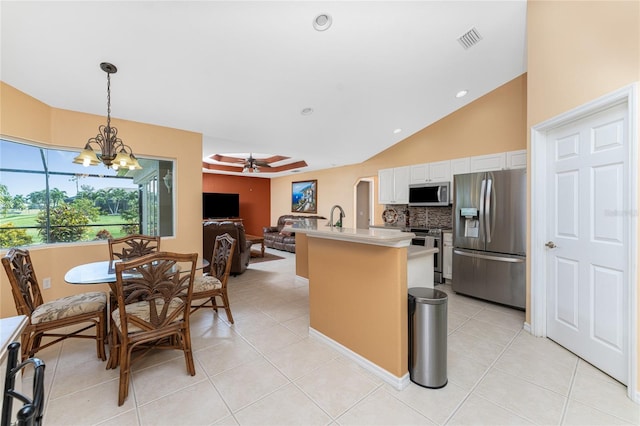 kitchen featuring light tile patterned floors, white cabinetry, ceiling fan with notable chandelier, pendant lighting, and stainless steel appliances