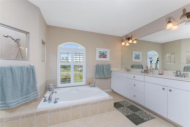 bathroom with vanity, tiled tub, and tile patterned flooring