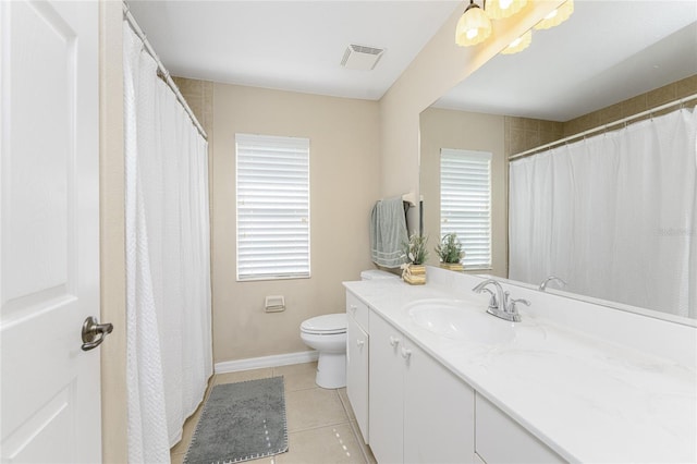 bathroom featuring toilet, a healthy amount of sunlight, vanity, and tile patterned flooring