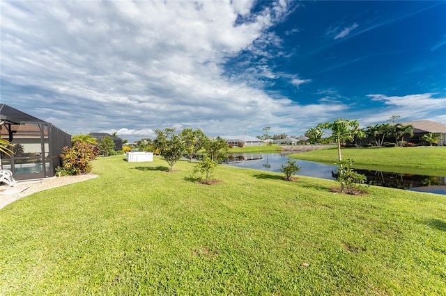 view of yard featuring a water view and glass enclosure