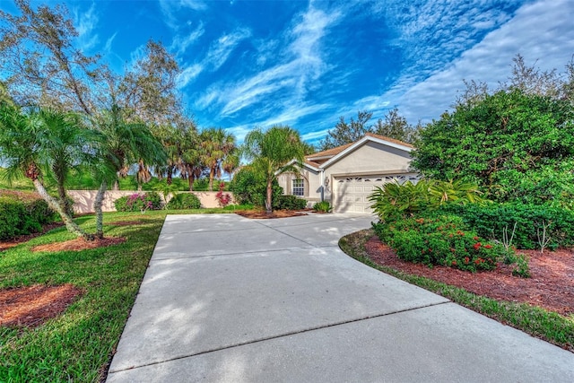 view of front of home with an attached garage, stucco siding, and driveway