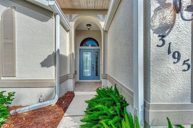 doorway to property featuring stucco siding