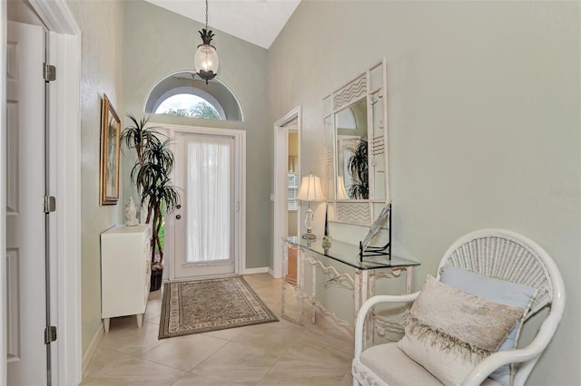 tiled foyer featuring high vaulted ceiling