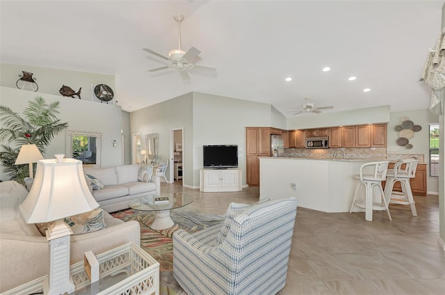 living room with ceiling fan, light tile patterned floors, and high vaulted ceiling