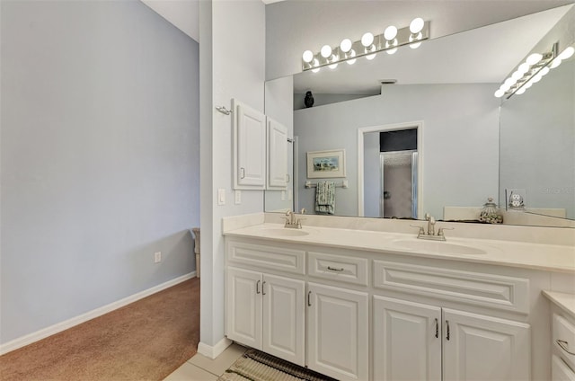 bathroom featuring vanity, lofted ceiling, and tile patterned flooring