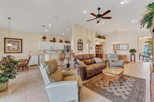 tiled living room with high vaulted ceiling and ceiling fan with notable chandelier