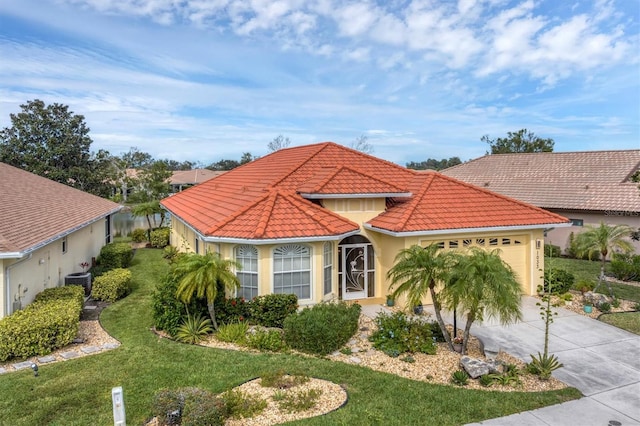 mediterranean / spanish-style home featuring cooling unit, a front lawn, and a garage