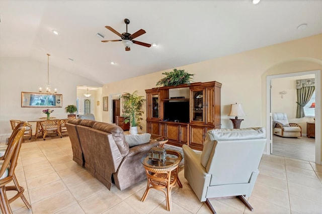 living room with light tile patterned flooring, ceiling fan with notable chandelier, and vaulted ceiling