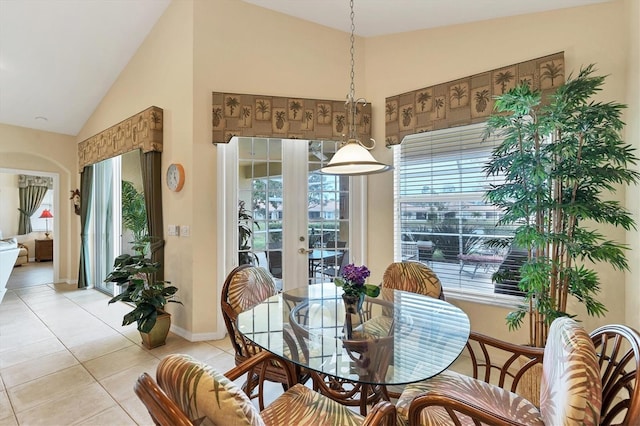 tiled dining space featuring vaulted ceiling