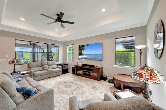 living room featuring a raised ceiling, crown molding, and ceiling fan