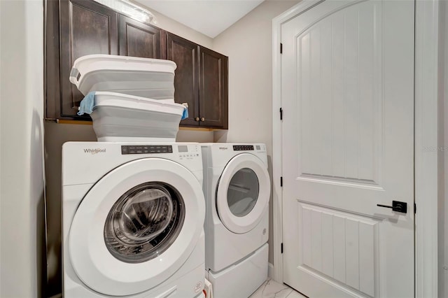 washroom with cabinets and washing machine and clothes dryer