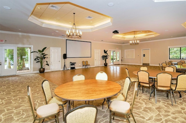 dining space featuring ornamental molding, a tray ceiling, and a notable chandelier