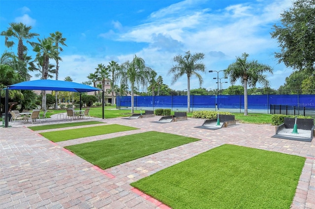 surrounding community with fence and a yard