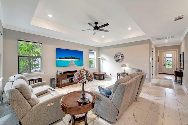 living room featuring crown molding, a tray ceiling, and ceiling fan