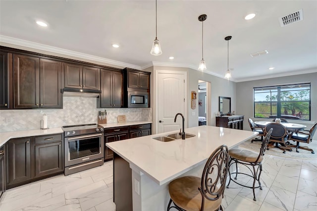 kitchen with built in microwave, an island with sink, sink, and high end stainless steel range