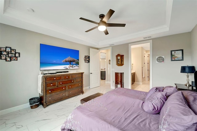 bedroom with connected bathroom, ceiling fan, and a tray ceiling