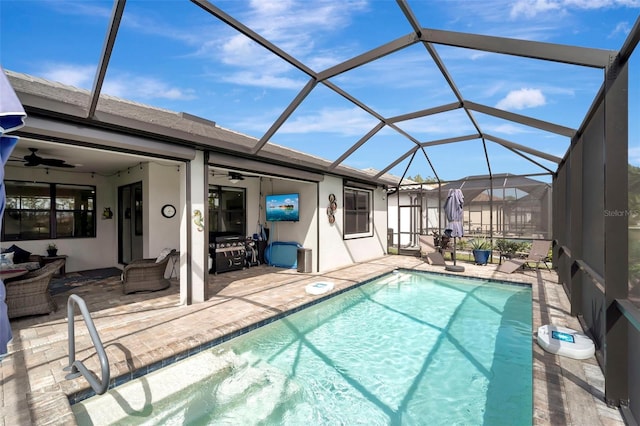 view of swimming pool featuring ceiling fan, a lanai, and a patio area