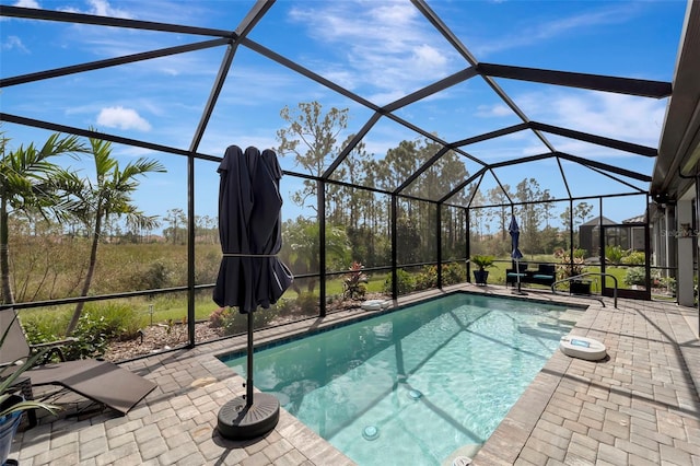 view of swimming pool featuring a patio and a lanai