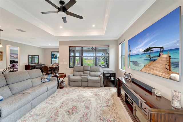 living room with crown molding, ceiling fan, and a tray ceiling