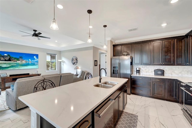 kitchen featuring sink, a kitchen island with sink, backsplash, hanging light fixtures, and stainless steel appliances