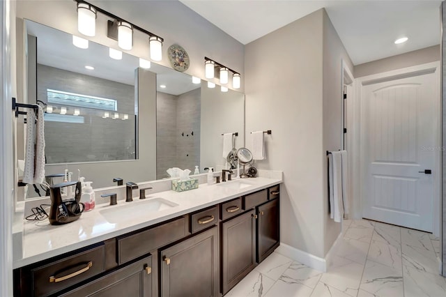 bathroom with a tile shower and vanity