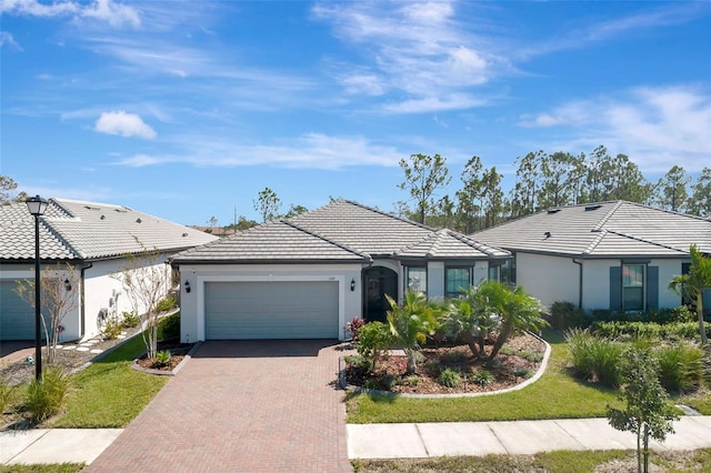 ranch-style home with a garage and a front lawn