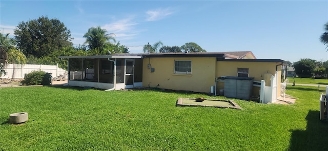 back of property featuring a lawn and a sunroom