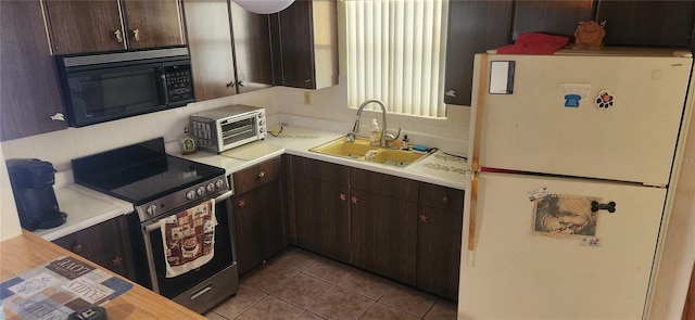 kitchen featuring sink, stainless steel electric stove, dark brown cabinetry, white fridge, and light tile patterned floors