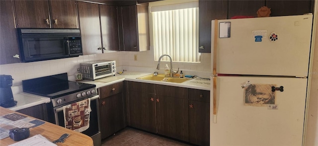 kitchen featuring stainless steel electric stove, white fridge, sink, and dark brown cabinets