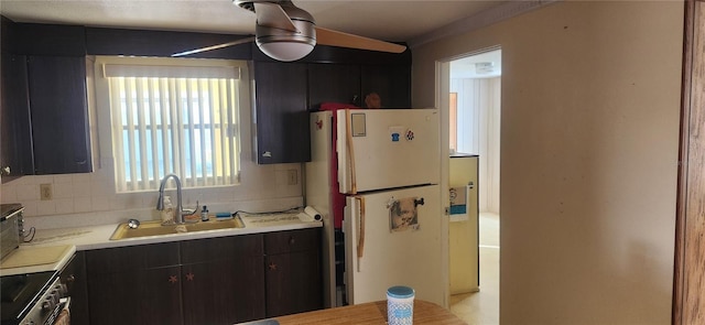 kitchen with sink, decorative backsplash, white fridge, and dark brown cabinets