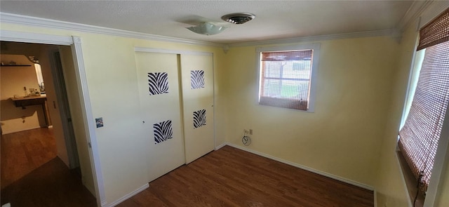 laundry room with a wealth of natural light, crown molding, and dark hardwood / wood-style floors